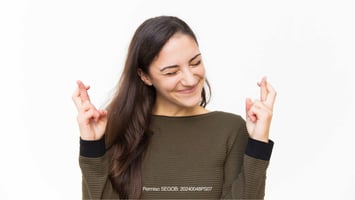 mujer cruzando dedos manifestando suerte 