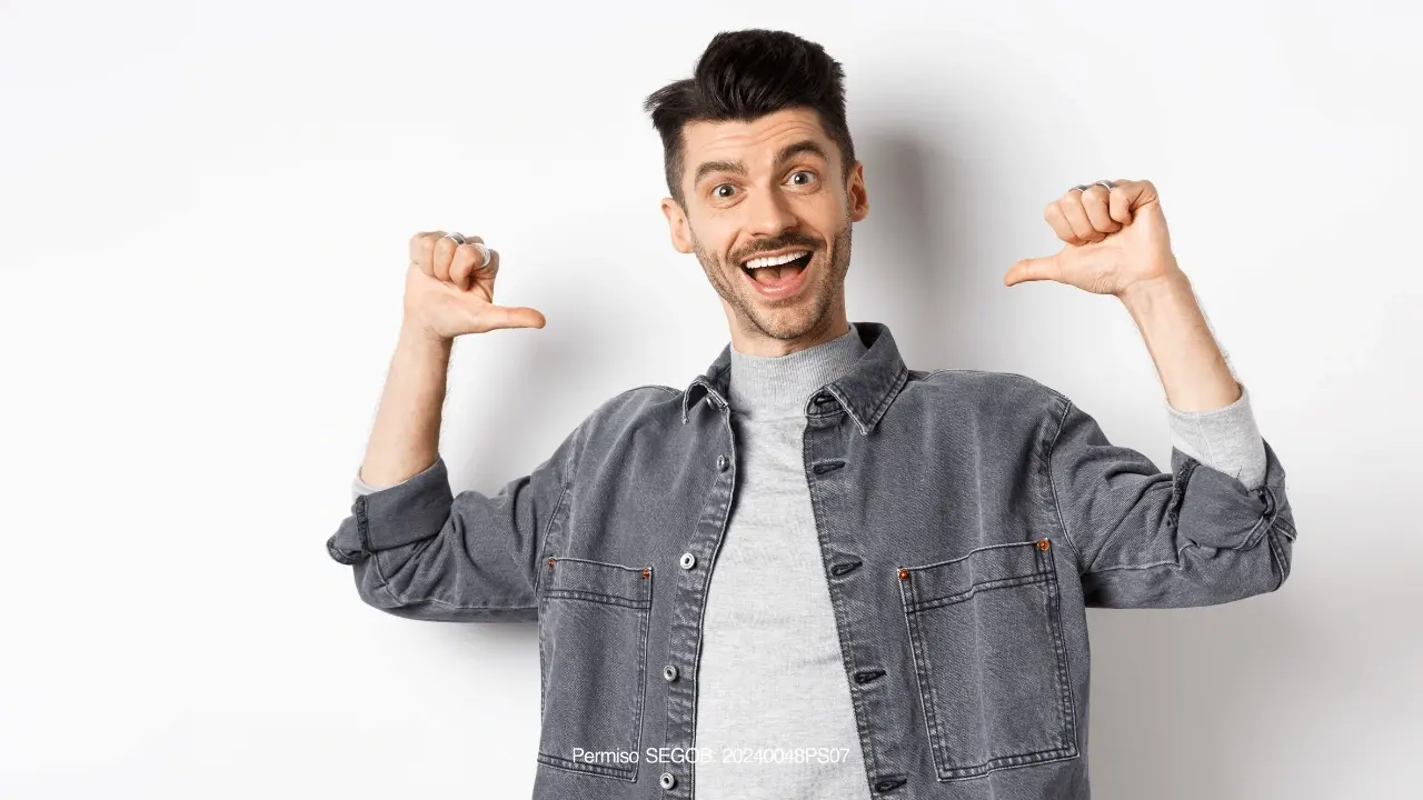 hombre sonriente apuntandose con los pulgares